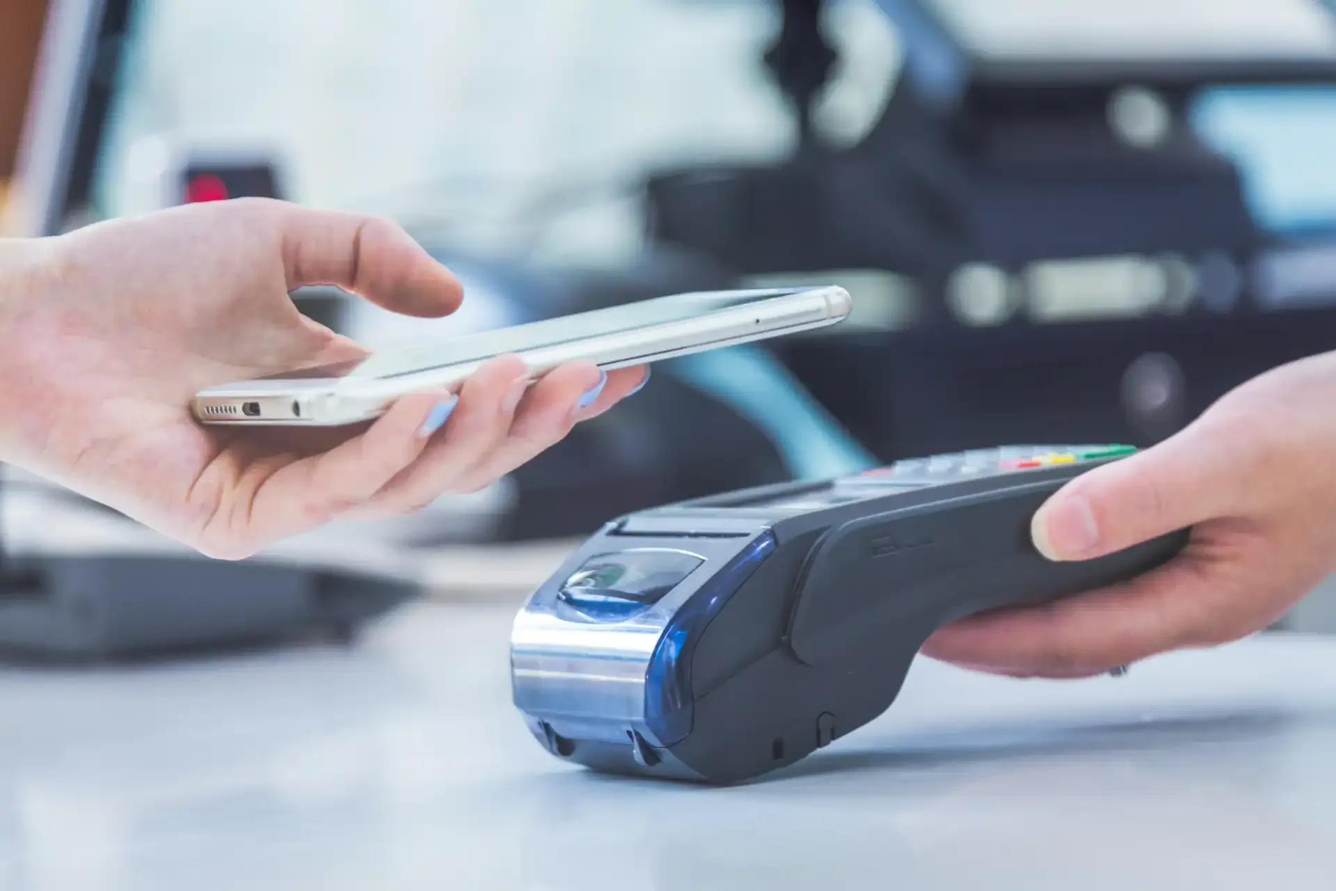 Pessoa realizando uma operação bancária digital usando um smartphone e um terminal de pagamento eletrônico, destacando facilidade e segurança na transação bancária digital.